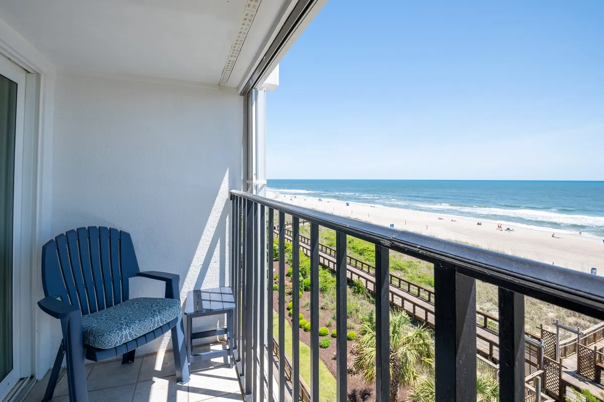 A private fourth-floor balcony with a chair overlooks the vast Atlantic Ocean. The tranquil setting suggests moments of relaxation, enjoying sunrises, or unwinding with a book or meal above the waves.